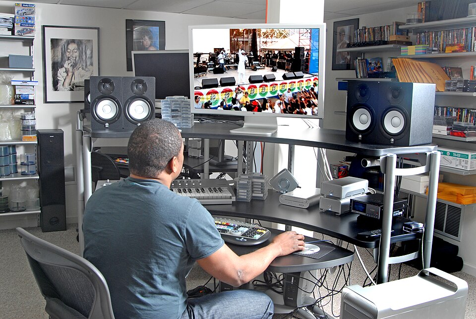 Professional video editor at workstation with multiple monitors and editing timeline