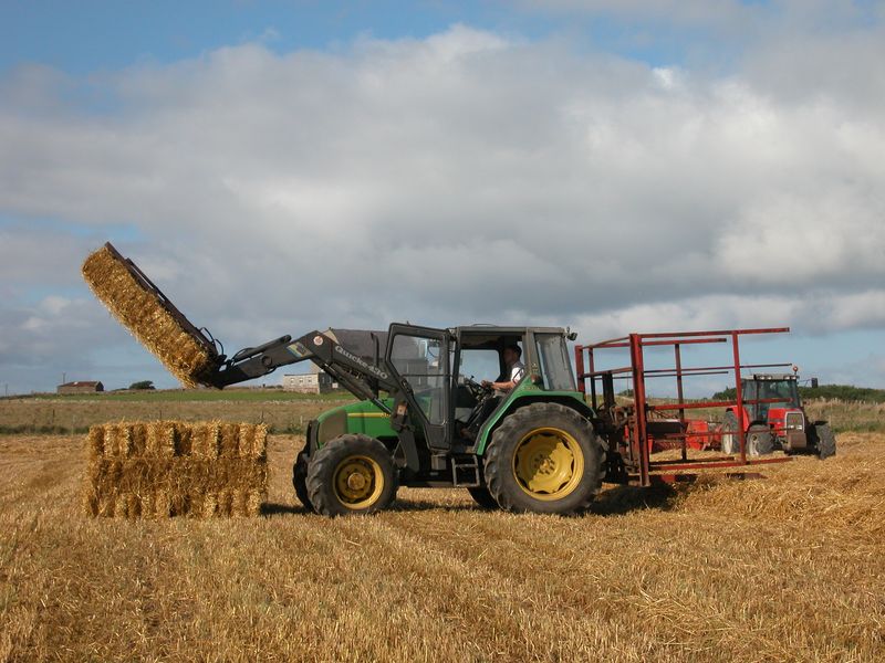 Green John Deere tractor with front-end loader on farm