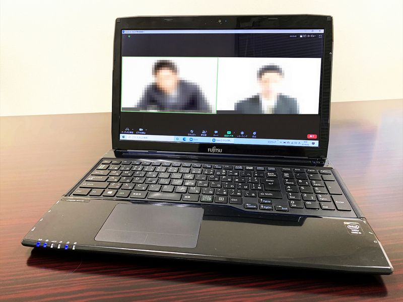 Person participating in video conference on laptop